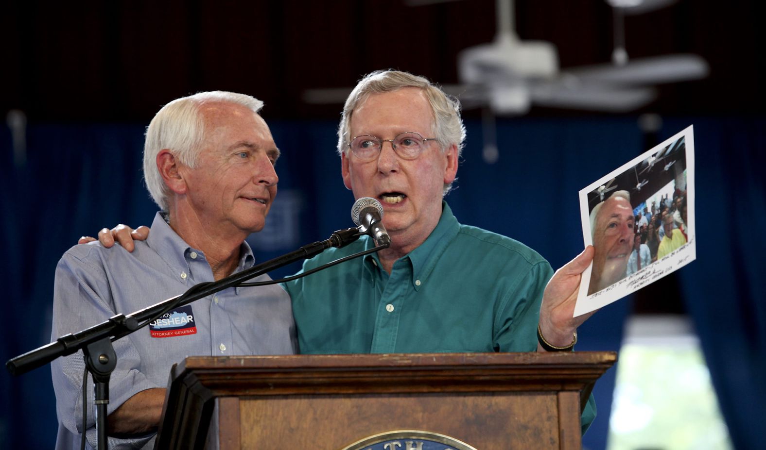 In August 2015, McConnell holds up a selfie photo that he took with Kentucky Gov. Steve Beshear, left, the year before. McConnell reminded Beshear that he falsely predicted that McConnell would lose his Senate race and retire. McConnell signed the photo for Beshear, who was term-limited and would be leaving office before him.