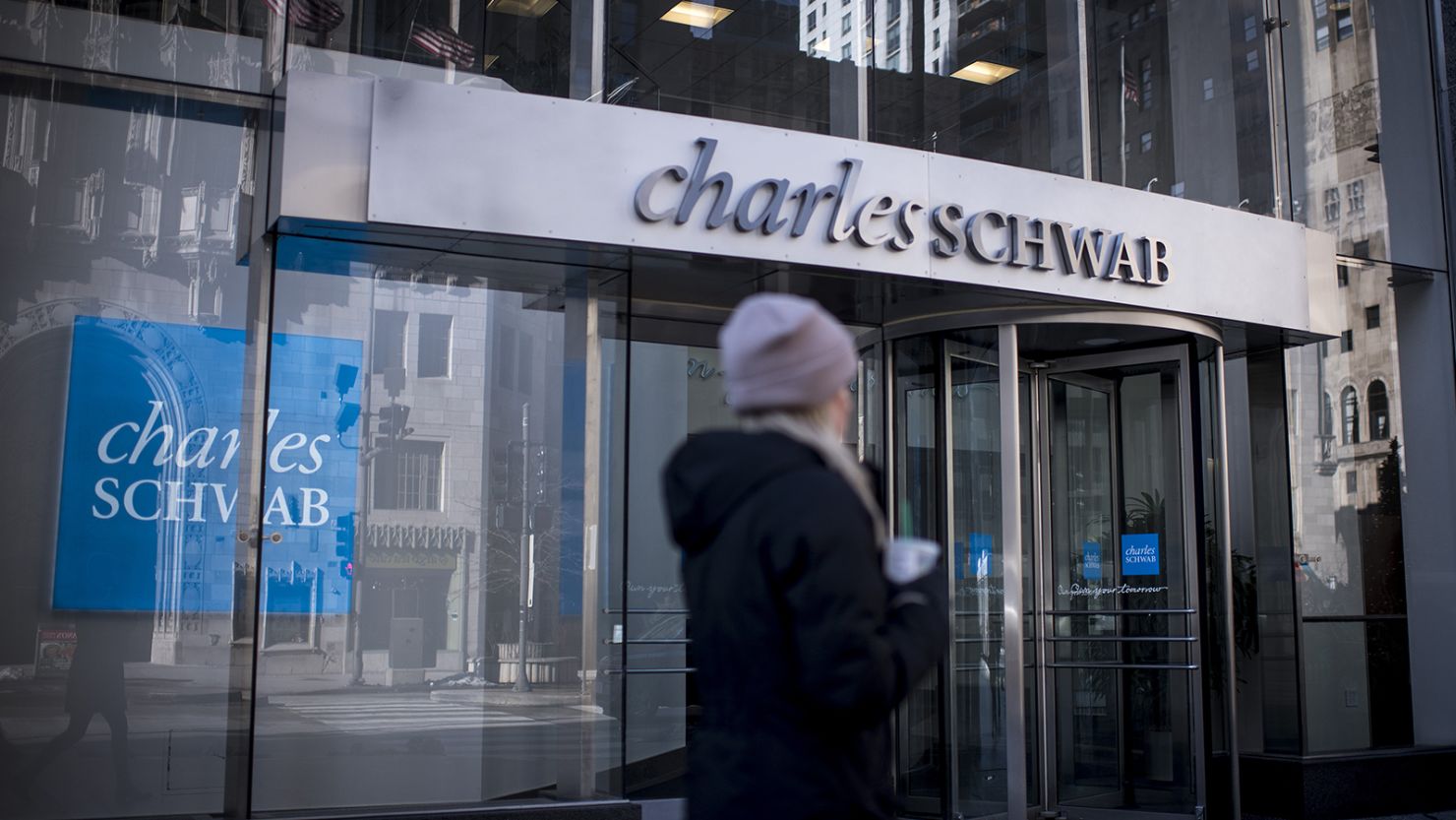 A pedestrian passes in front of a Charles Schwab Corp. bank branch in downtown Chicago, Illinois, U.S., on Monday, Jan. 8, 2018.