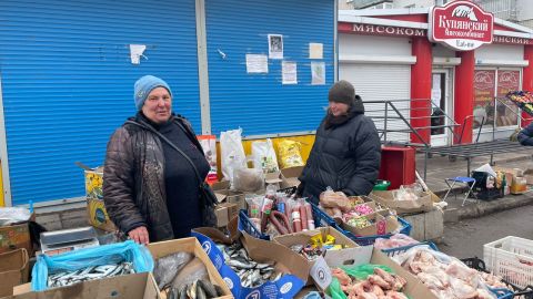 Lida, seen at her makeshift market stall, says she will stay in the city and hide where she despite the continued shelling.