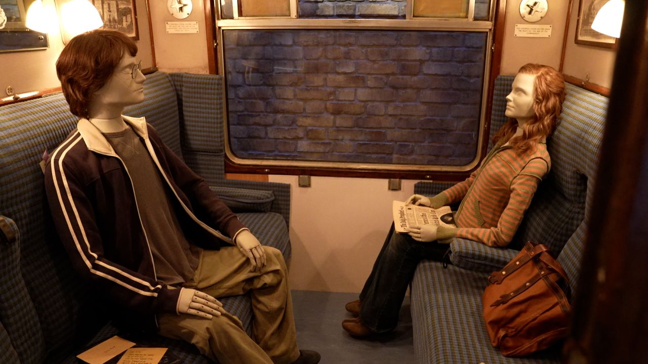 Mannequins representing the characters of Harry Potter and Hermione Granger on board the set of the Hogwarts Express in Tokyo.