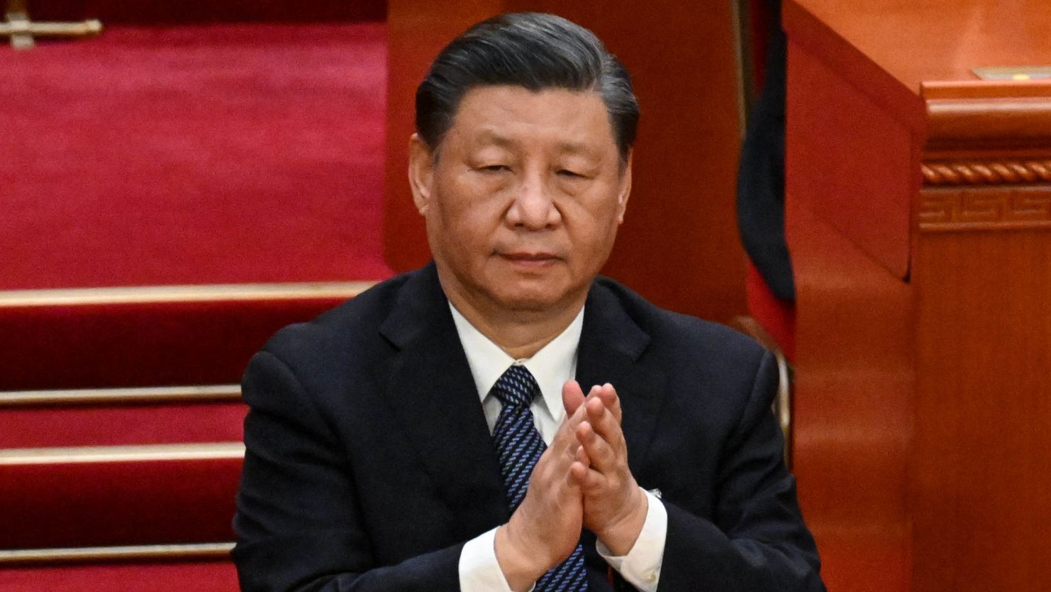 China's leader Xi Jinping applauds during the fifth plenary session of the National People's Congress (NPC) at the Great Hall of the People in Beijing on March 12, 2023. 