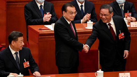Mantan Perdana Menteri China Li Keqiang berjabat tangan dengan penggantinya Perdana Menteri Li Qiang saat pemimpin China Xi Jinping memandang.