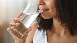 Healthcare Concept. Unrecognizable African Girl Drinking Glass of Mineral Water At Home, Cropped Image, Panorama With Copy Space