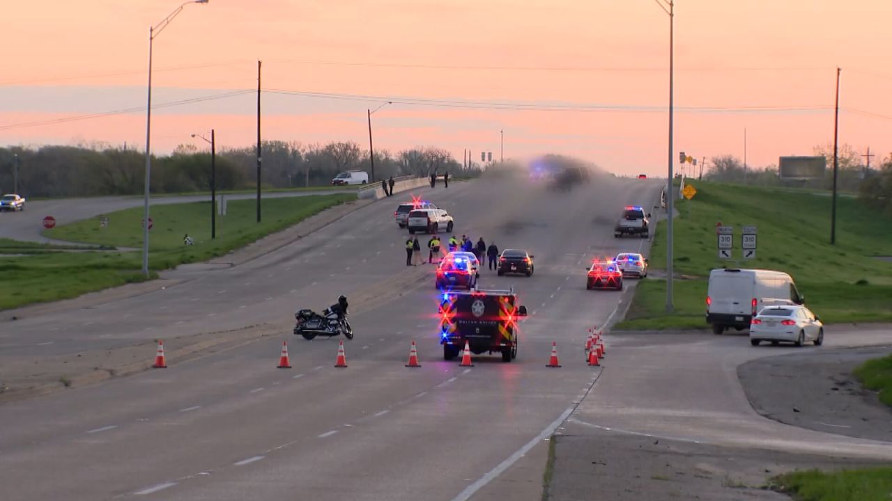 Emergency personnel work the scene of a crash Tuesday in Dallas, Texas, where one person and two horses died after they were struck by a vehicle. A graphic portion of this image has been blurred by CNN affiliate KTVT.