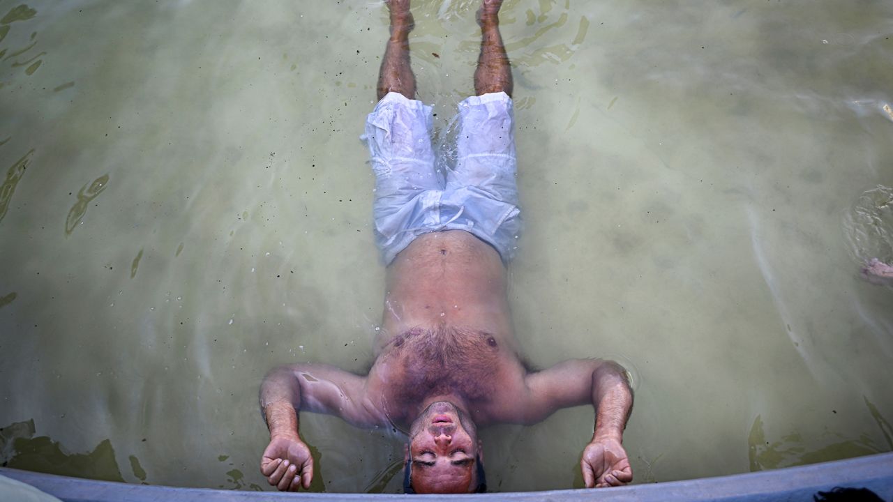 A man cools off in a fountain on 9 de Julio avenue in Buenos Aires, Argentina, on March 8, 2023.