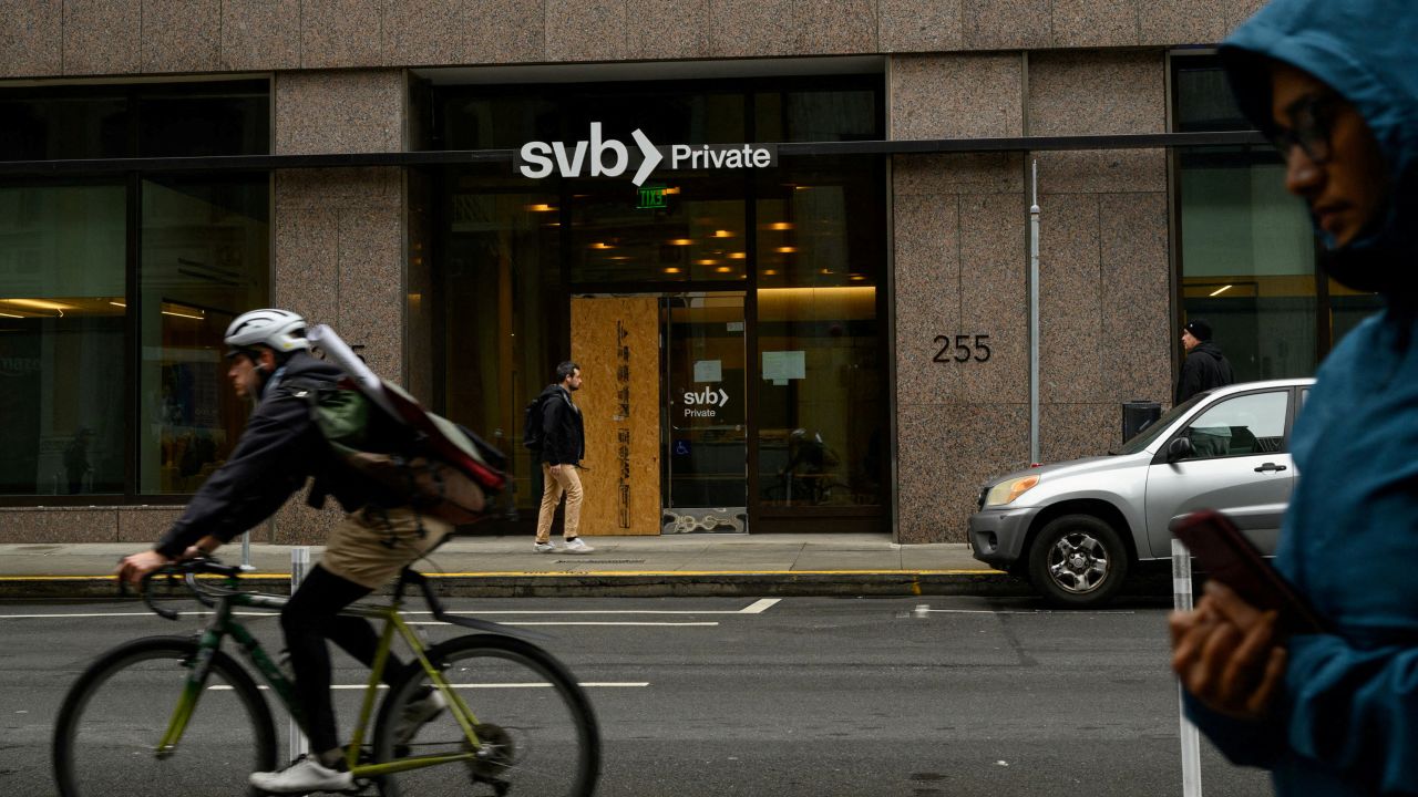 FILE PHOTO: Pedestrians and a cyclist pass by the Silicon Valley Bank branch office in downtown San Francisco, California, U.S., March 13, 2023. REUTERS/Kori Suzuki/File Photo
