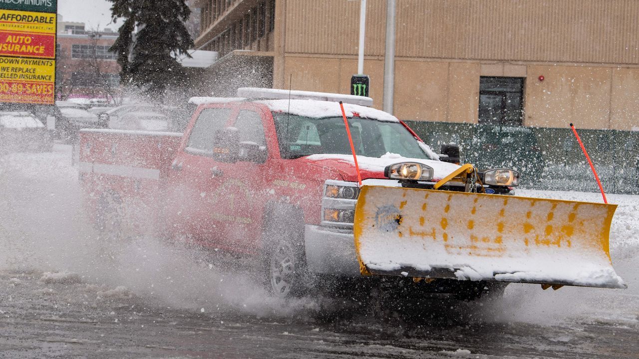 A plow moves through a partially flooded intersection in Worcester, Massachusetts, on March 14, 2023.