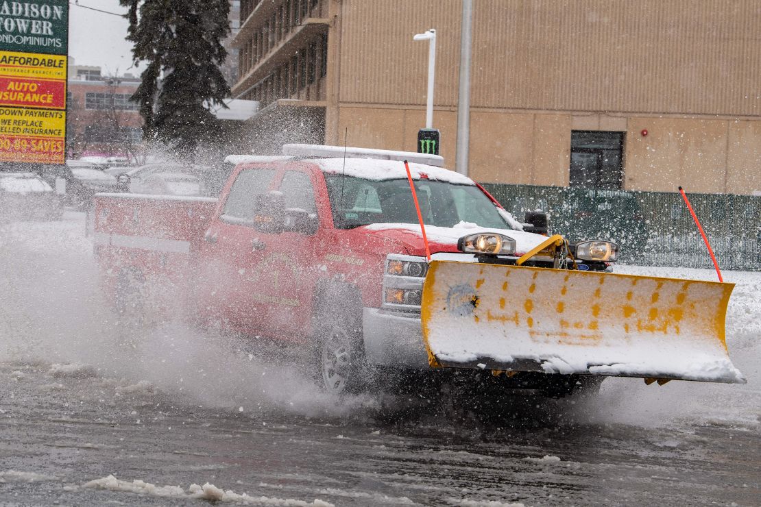 A plow moves through a partially flooded intersection in Worcester, Massachusetts, on March 14, 2023. 