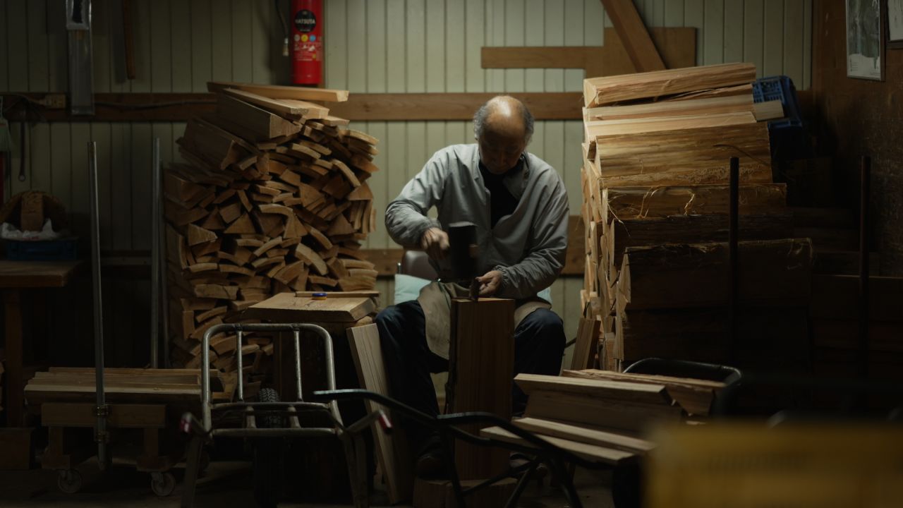 કાઓરુ હરુમાશી બેરલ બનાવવા માટે દેવદારના લાકડા પર કામ કરે છે.