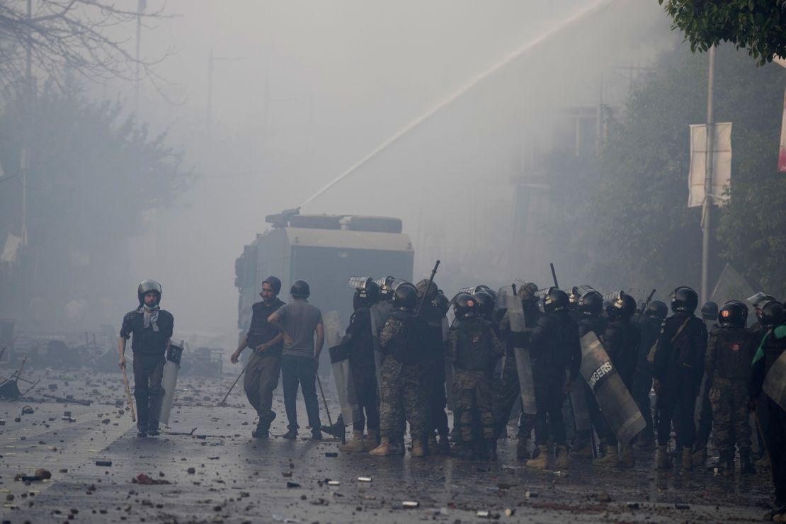 Police use water cannons to disperse supporters of former Prime Minister Imran Khan during clashes, in Lahore on Wednesday.