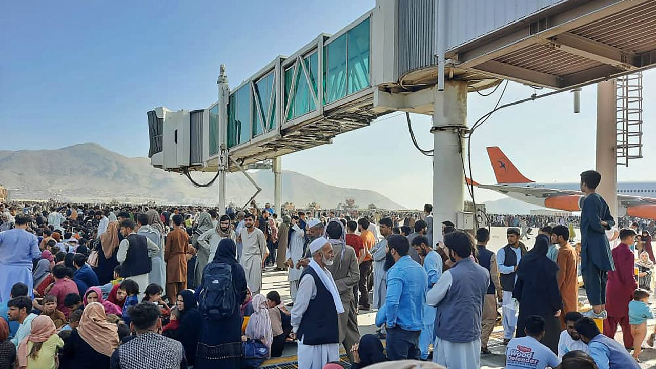 Afghans crowd at the tarmac of the Kabul airport on August 16, 2021, to flee the Taliban which had gained  control of Afghanistan