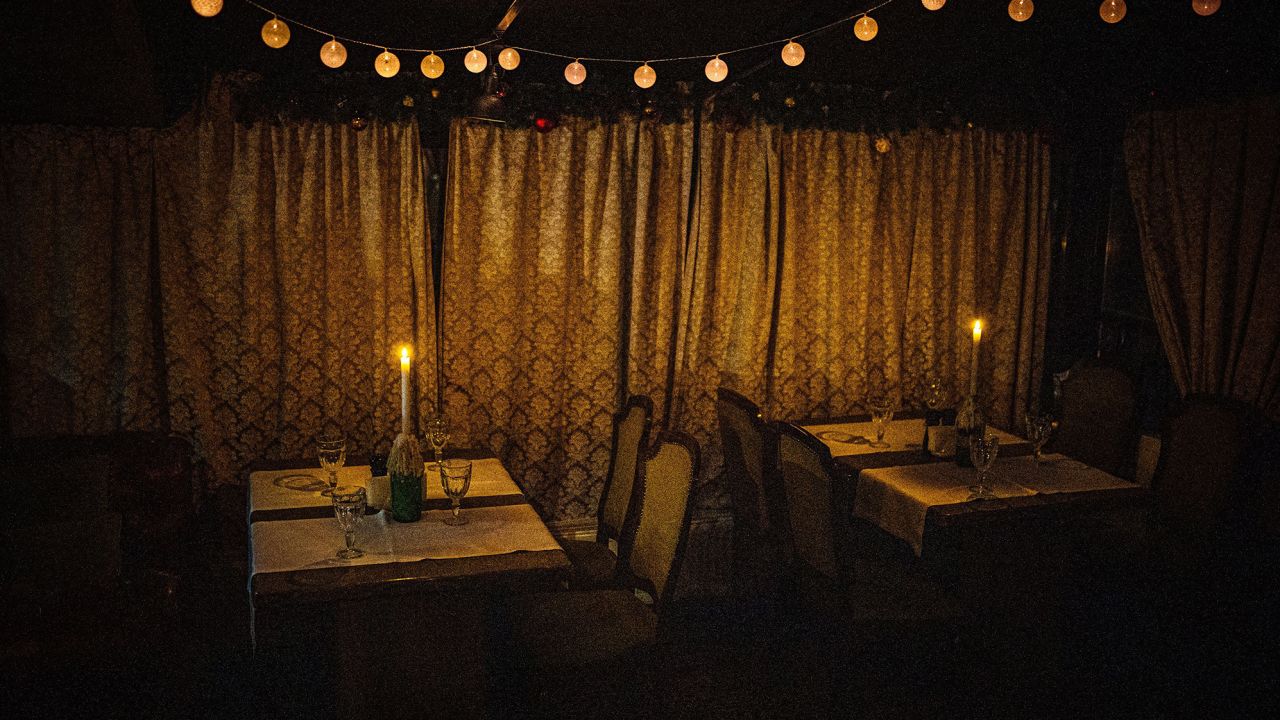 Candles light an empty restaurant during a power cut in downtown Kyiv, December 2022. 