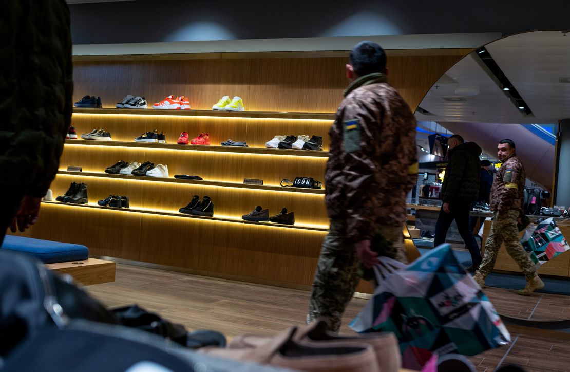 A soldier shops in a Kyiv mall, in December 2022. As the war grinds on, Ukraine's economy continues to suffer.