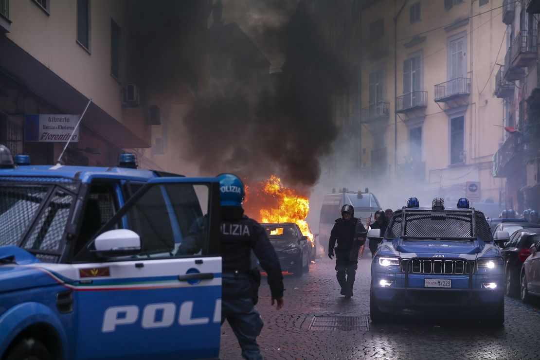 Supporters of Eitracht Frankfurt set a police car on fire as they clash with police.