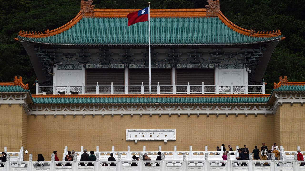 Tourists walk in front of Taiwan's National Palace Museum in Taipei on March 13, 2019. 