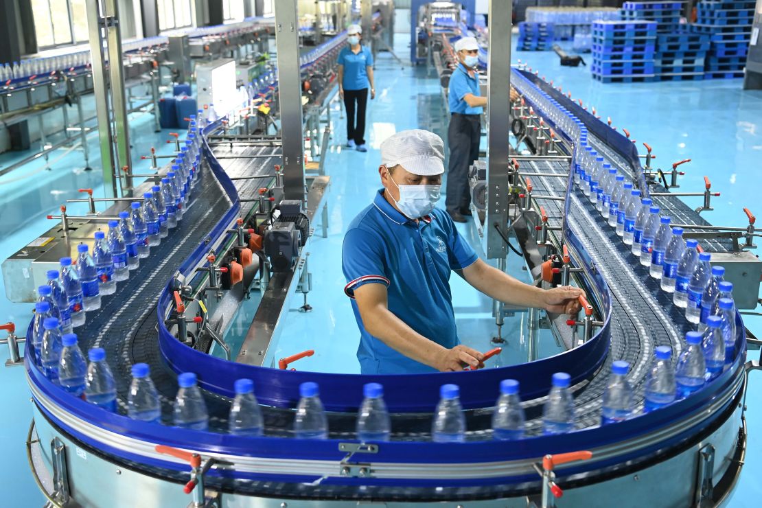 Employees work on the production line of plastic bottled water at a factory in Yichun, Jiangxi Province of China, in 2022.