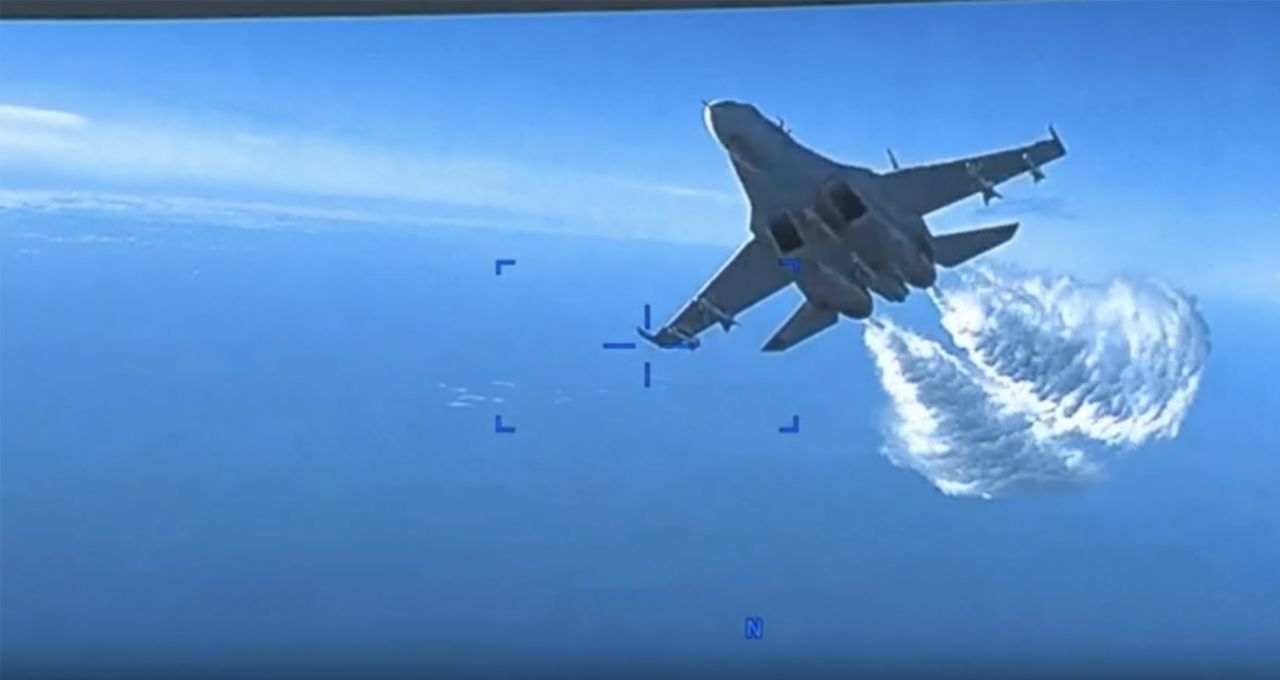 A still taken from video footage released by the US European Command shows an encounter between a US surveillance drone and Russian fighter jets over the Black Sea on Tuesday, March 14. The MQ-9 Reaper drone and two Russian Su-27 aircraft were flying over international waters when one of the Russian jets intentionally flew in front of and dumped fuel on the unmanned drone several times, a statement from US European Command said. The aircraft then hit the propeller of the drone, prompting US forces to bring the drone down in the Black Sea.