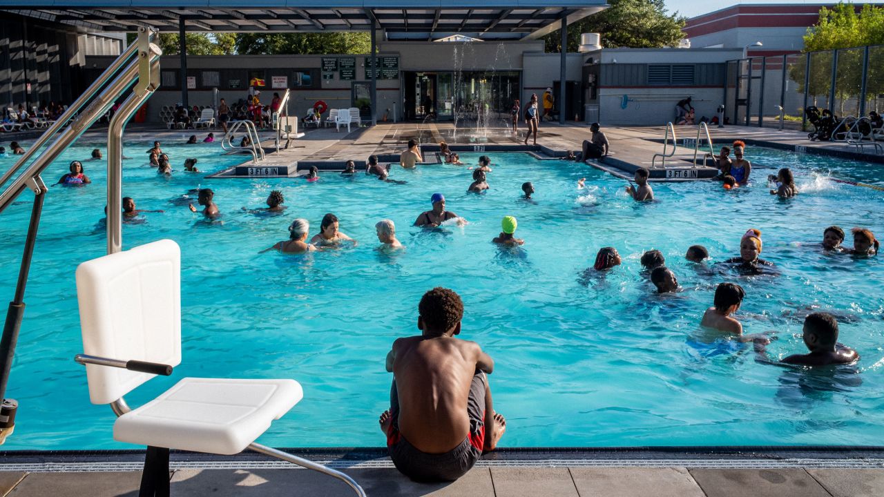 A child watches others swim at the Emancipation Swimming Pool on July 19, 2022, in Houston.