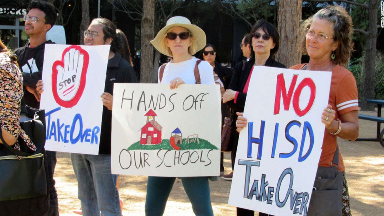 People hold up signs at a news conference on March 3, 2023, in Houston while protesting the proposed takeover of the city's school district by the Texas Education Agency.