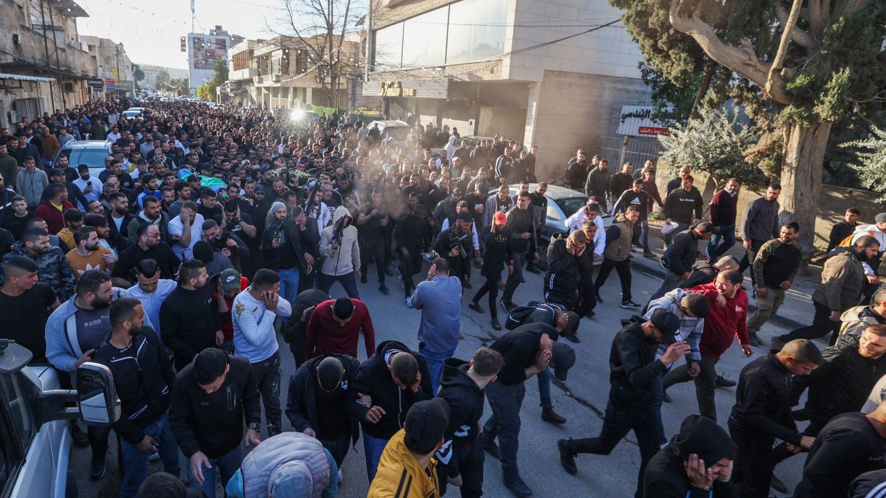 Gunmen fire in the air as mourners carry the bodies of Palestinians killed in an Israeli raid in Jenin on March 16, 2023.  