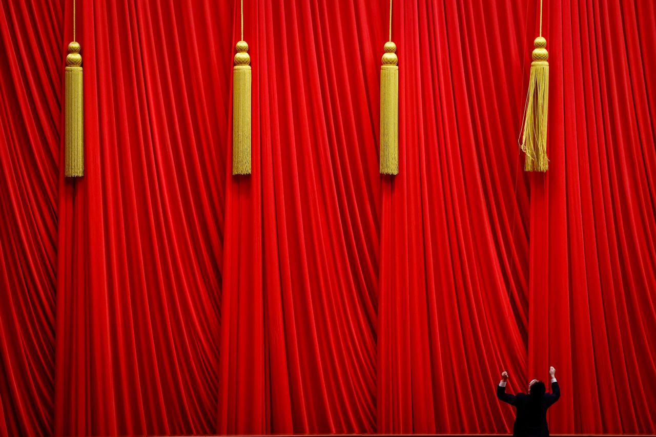 A man fixes curtains ahead of the fifth plenary session of the National People's Congress in Beijing on Sunday, March 12.