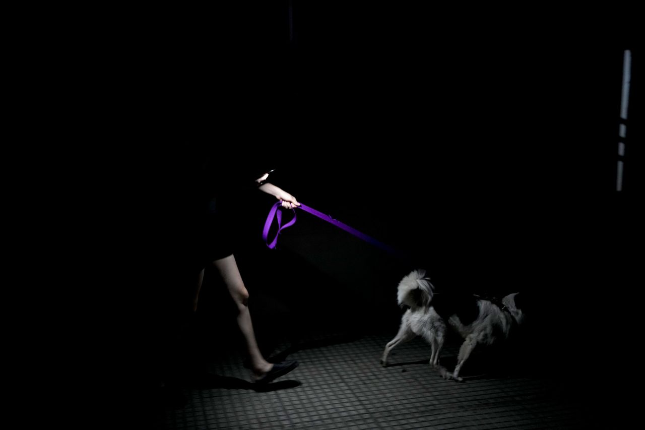 A resident walks her dog during a power outage amid a heat wave in Buenos Aires on Tuesday, March 14. Argentina is grappling with an unprecedented late-summer heatwave as temperatures soar to record-breaking levels.
