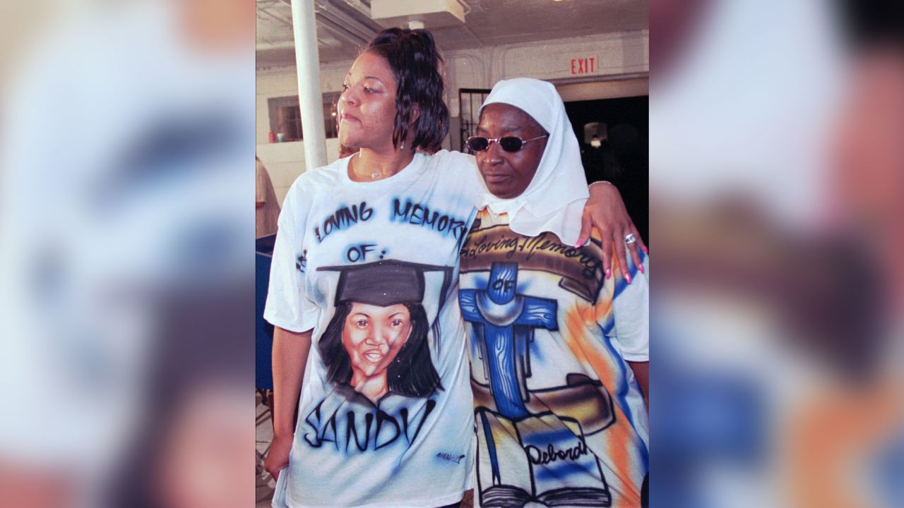 Tracey Lomax, kiri, dan Carolyn Johnson memakai baju tersuai untuk mengenang adik perempuan mereka yang terbunuh pada sidang akhbar selepas hukuman mati Gary Heidnik pada tahun 1999. 