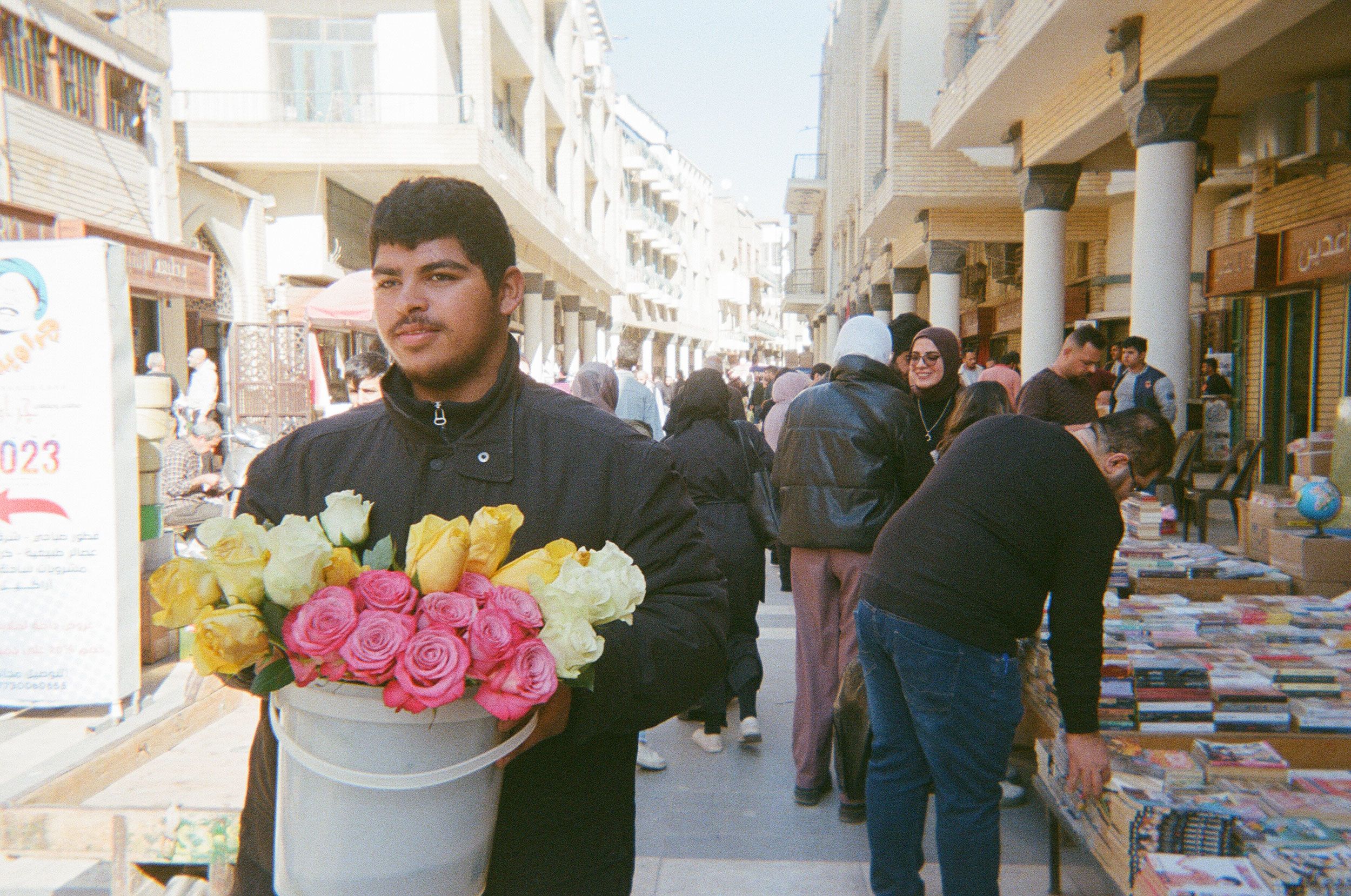 Man carrying roses through al-Mutanabbi Street in Baghdad.