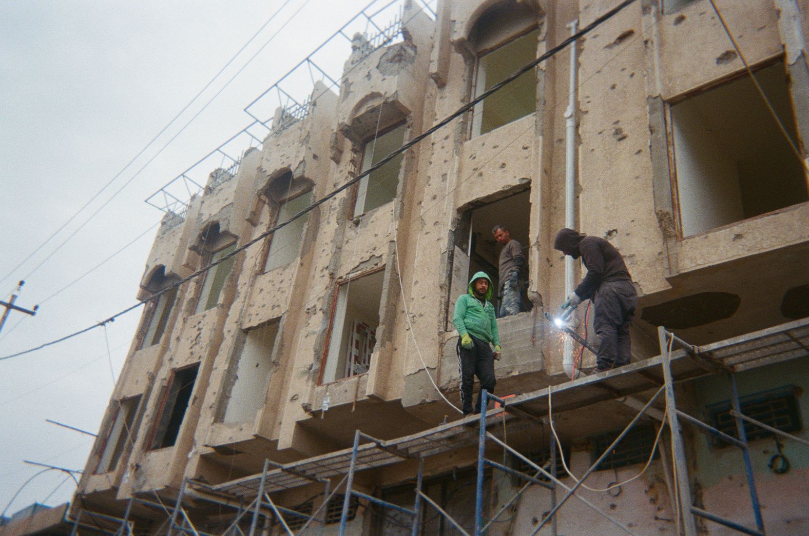 Men work to restore a building still riddled with bullet holes after being damaged in the <a href="http://www.cnn.com/2004/WORLD/meast/11/08/iraq.main/" target="_blank">Second Battle for Falluja</a> in November 2004.<br /><br />Nawfel, the photographer, was just 9 months old when this happened, but he said his family had to flee the city to escape the war. "I am 19 years old, so I don't really remember much about major events in Iraq," he said.<br /><br />But he does remember the war against ISIS and the <a href="https://www.cnn.com/2019/10/02/world/iraq-protests-baghdad-intl/index.html" target="_blank">2019 mass protests</a> he participated in against unemployment, government corruption and the lack of basic services.<br /><br />"My parents told me some stories about life before the US invasion to Iraq," he said. "The city of Falluja used to be more organized, much cleaner and most importantly it used to be safer. Things are getting better but very slowly."