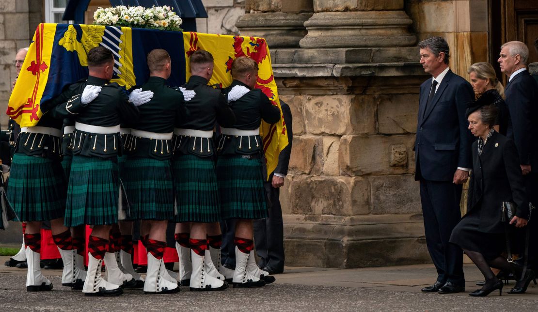 Princess Anne curtsies to the coffin of Queen Elizabeth II, draped with the Royal Standard of Scotland, as it is carried in to the Palace of Holyroodhouse, in Edinburgh on September 11, 2022. 