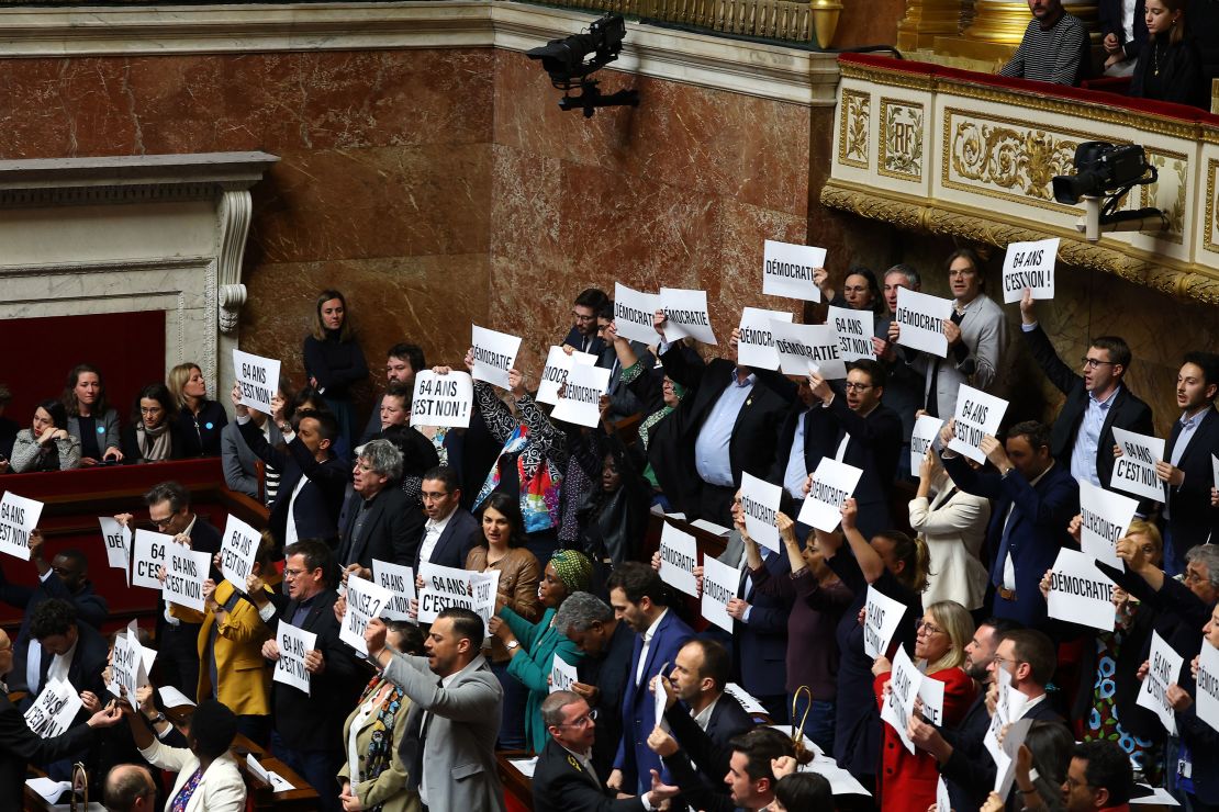 Members of Parliament of left-wing coalition NUPES (New People's Ecologic and Social Union) hold placards as French Prime Minister Elisabeth Borne addresses deputies to confirm the force through of the pension law without a parliament vote on Thursday.