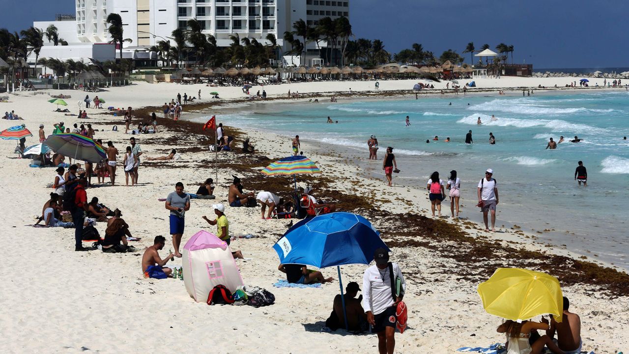 Tourists enjoy the beach despite the sargassum algae buildup in Cancun, Mexico, in May 2021. 