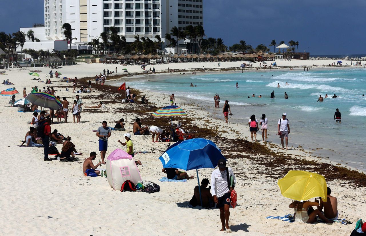 Tourists enjoy the beach despite the sargassum algae buildup in Cancun, Mexico, in May 2021. 