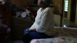 One senior black woman sitting by bedside in bedroom