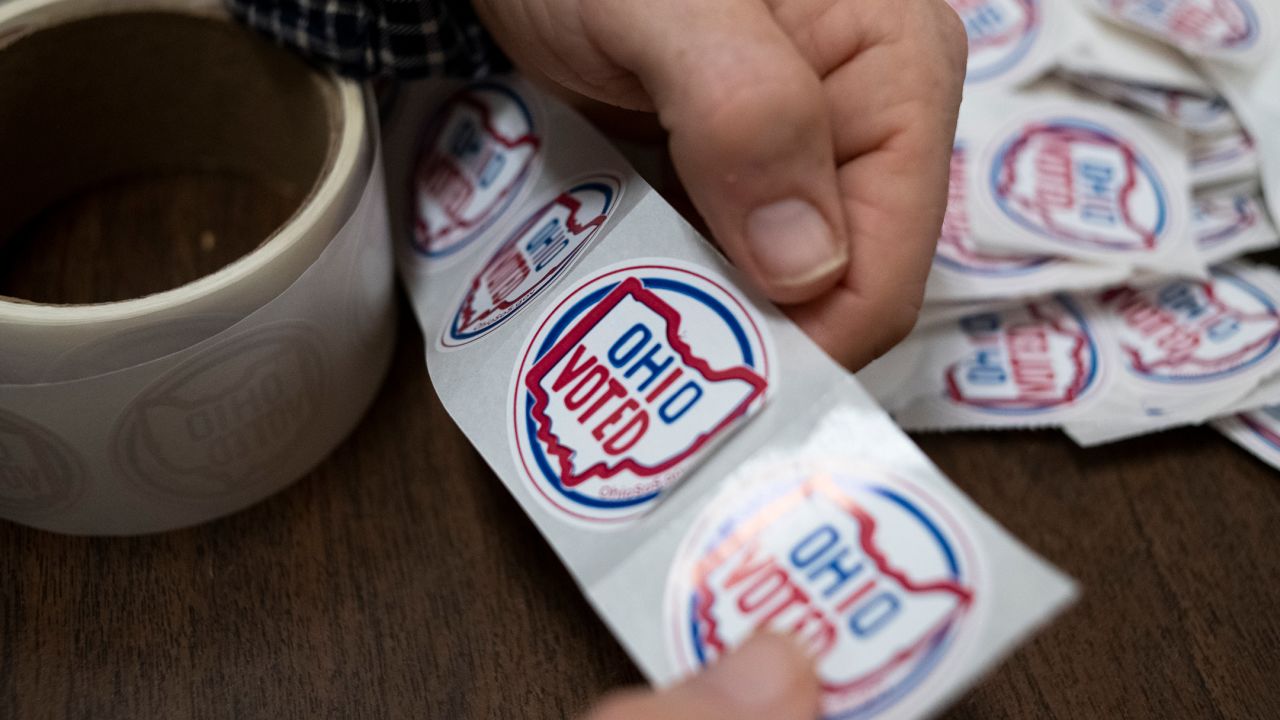 A volunteer tears OHIO VOTED stickers from a roll so early voters could grab one after voting inside of the Franklin County Board of Elections Office on October 6, 2020, in Columbus, Ohio.