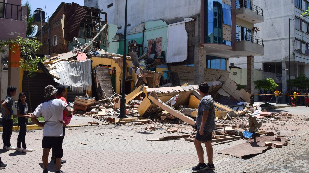 Residents look at a building that collapsed after an earthquake in Machal, Ecuador, on March 18, 2023.