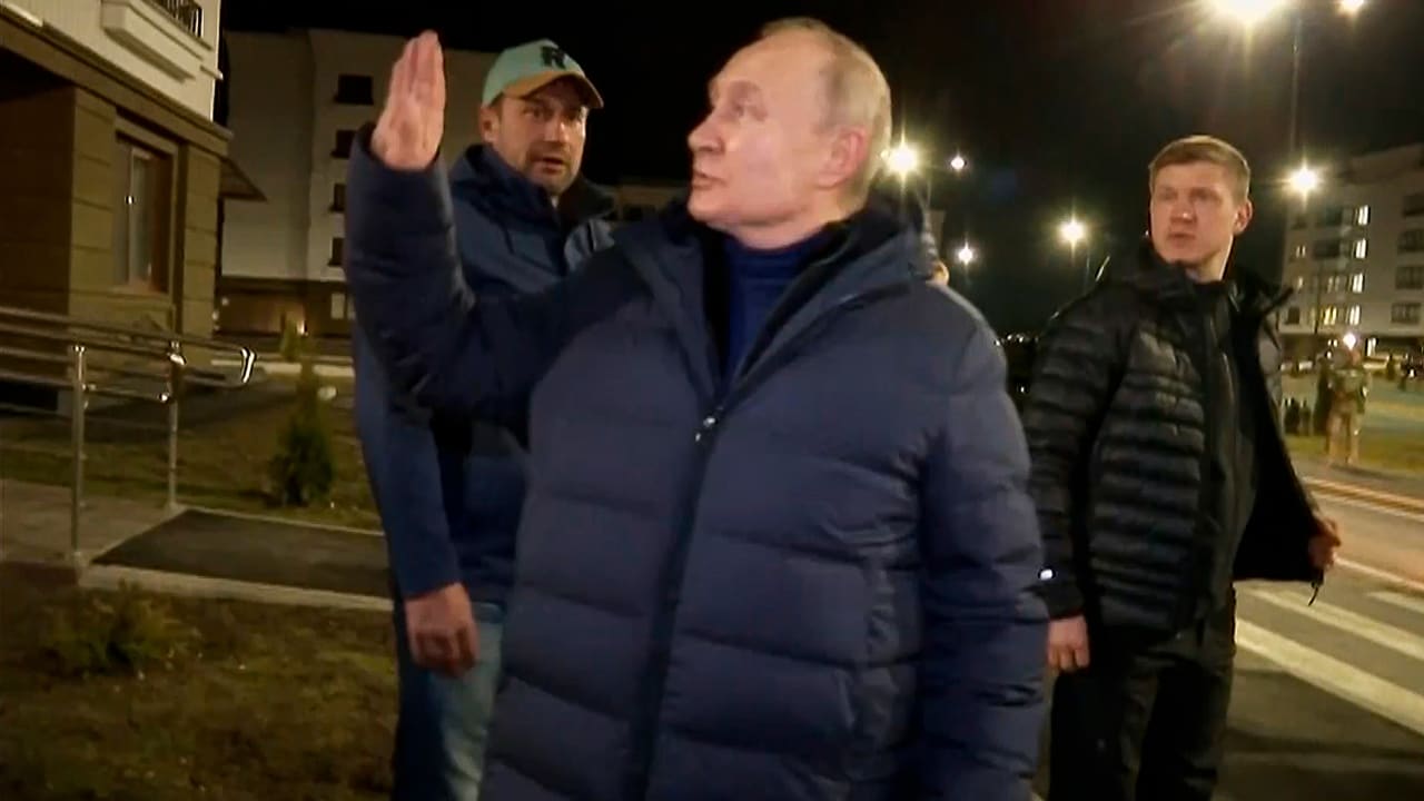 In this photo taken from video released by Russian TV Pool on Sunday, March 19, 2023, Russian President Vladimir Putin waves local residents after visiting their new flat during his visit to Mariupol in Russian-controlled Donetsk region, Ukraine. Putin has traveled to Crimea to mark the ninth anniversary of the Black Sea peninsula's annexation from Ukraine.