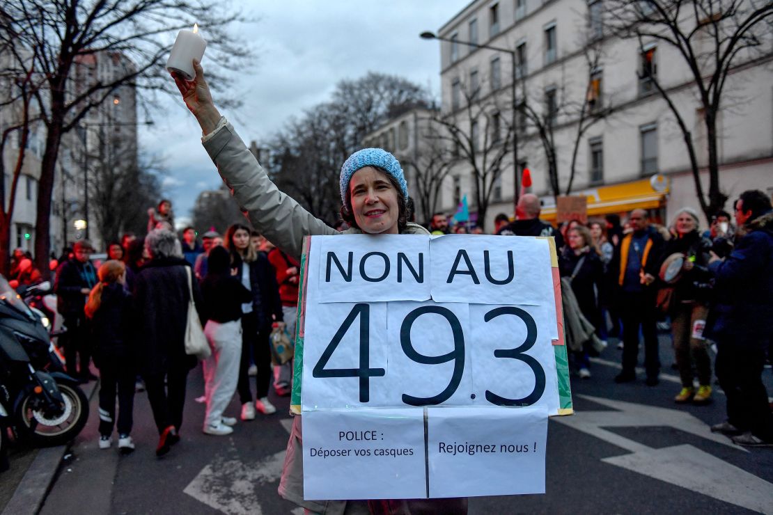 "No to 49.3," reads a sign held by a protester.