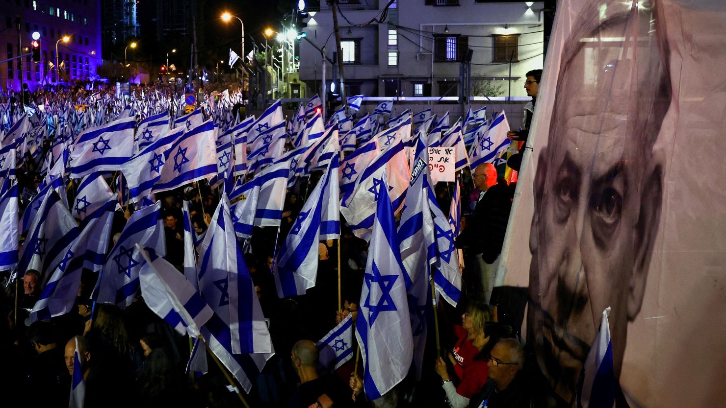 Demonstrators hold Israeli flags next to an image of Prime Minister Benjamin Netanyahu in Tel Aviv, Israel, on Saturday.