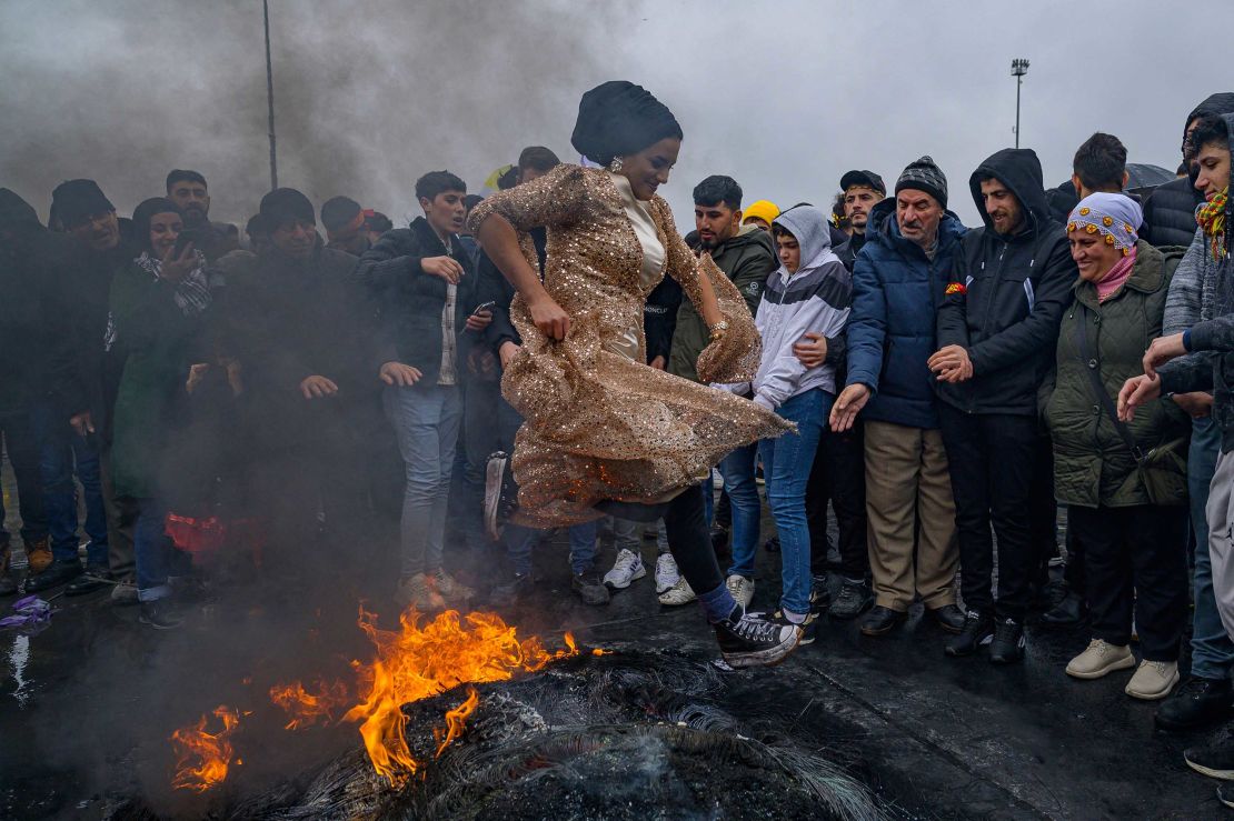 A woman jumps over a bonfire during a Kurdish celebration of Nowruz, the new year of the Persian calendar, in Istanbul on Sunday.  