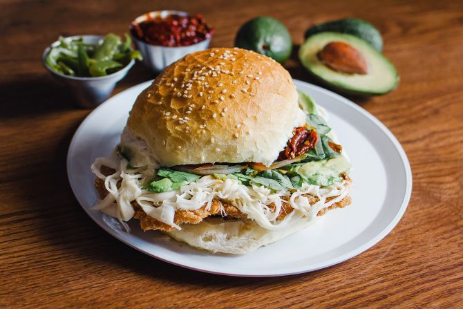 <strong>Cemita: </strong>The cemita is a specialty of Puebla and features a sesame seed-covered, brioche-like roll filled with battered and fried cutlets of protein such as pork, beef or chicken and toppings.
