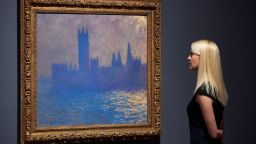 A woman poses by a painting of the Houses of Parliament by French artist Claude Monet during a press preview for the exhibition French Artists in Exile (1870-1904) at Tate Britain in London on October 30, 2017  / AFP PHOTO / NIKLAS HALLE'N / RESTRICTED TO EDITORIAL USE - MANDATORY MENTION OF THE ARTIST UPON PUBLICATION - TO ILLUSTRATE THE EVENT AS SPECIFIED IN THE CAPTION        (Photo credit should read NIKLAS HALLE'N/AFP via Getty Images)