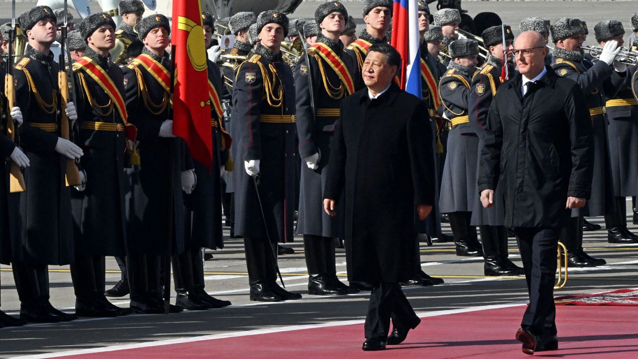 El líder chino Xi Jinping, acompañado por el viceprimer ministro ruso Dmitry Chernyshenko, pasa junto a una guardia de honor durante una recepción en el aeropuerto Vnukovo de Moscú el 20 de marzo de 2023. 