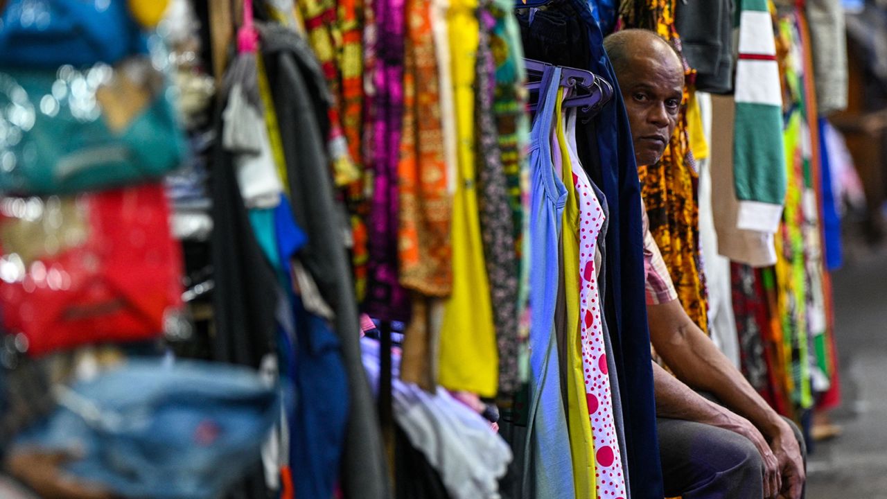 A vendor selling clothes waits for customers at a market in Colombo, Sri Lanka on March 20, 2023. 