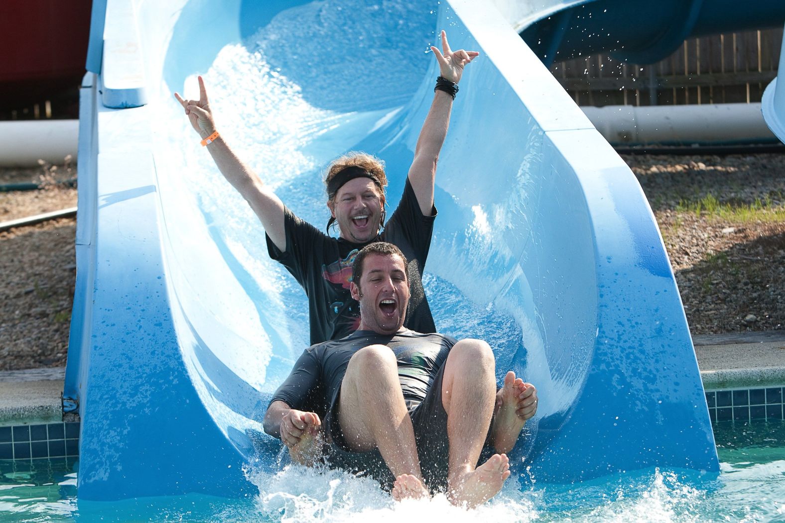 Sandler and Spade go down a water slide in the 2010 comedy "Grown Ups."