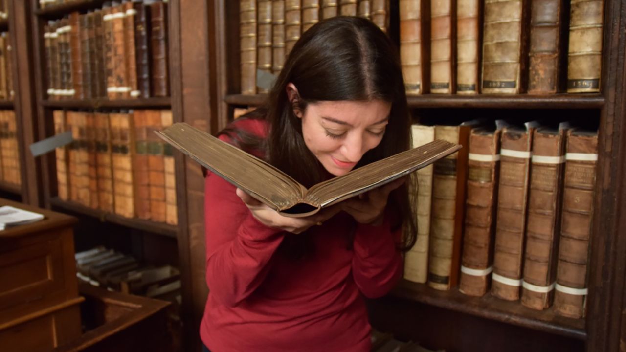 Cecilia Bembibre sniffs a historic book at St Paul's Cathedral's library.