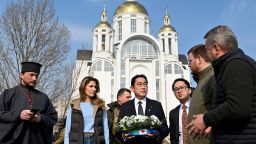 Japan's Prime Minister Fumio Kishida (C) visits the site of a mass grave found on the grounds of the church of Saint Andrew Pervozvannoho All Saints in the town of Bucha, during his visit to Ukraine on March 21, 2023, amid the Russian invasion of Ukraine. (Photo by Sergei CHUZAVKOV / AFP) (Photo by SERGEI CHUZAVKOV/AFP via Getty Images)