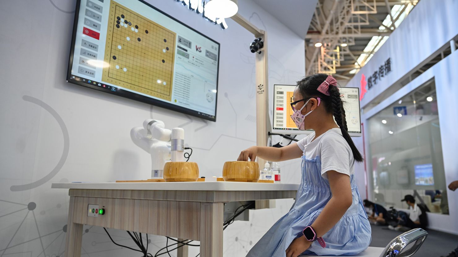 A young visitor plays Go with an AI robot during a special exhibition of the 5th Digital China Summit in Fuzhou, southeast China's Fujian Province, in July 2022. 