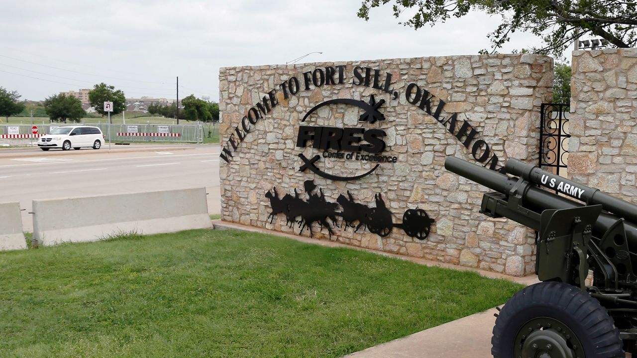 A vehicle drives by a sign at Scott Gate, one of the entrances to Fort Sill, in Fort Sill, Oklahoma.