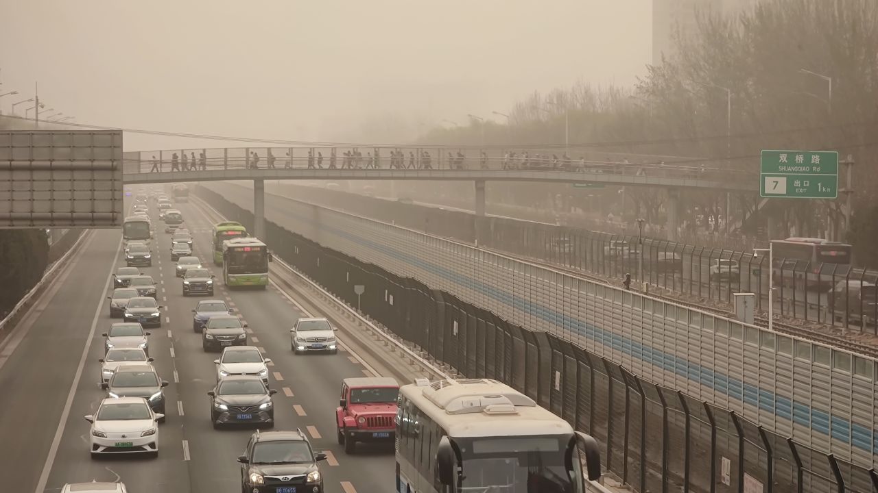 Cars drive in low-visibility through a sandstorm on March 22, 2023 in Beijing, China.